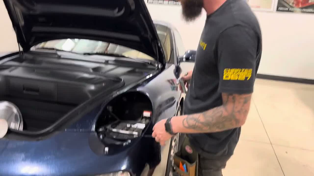 Wet the panel and keep the adhesive clean Wetting the dark blue Porsche 997 front fender before fitting paint protection film