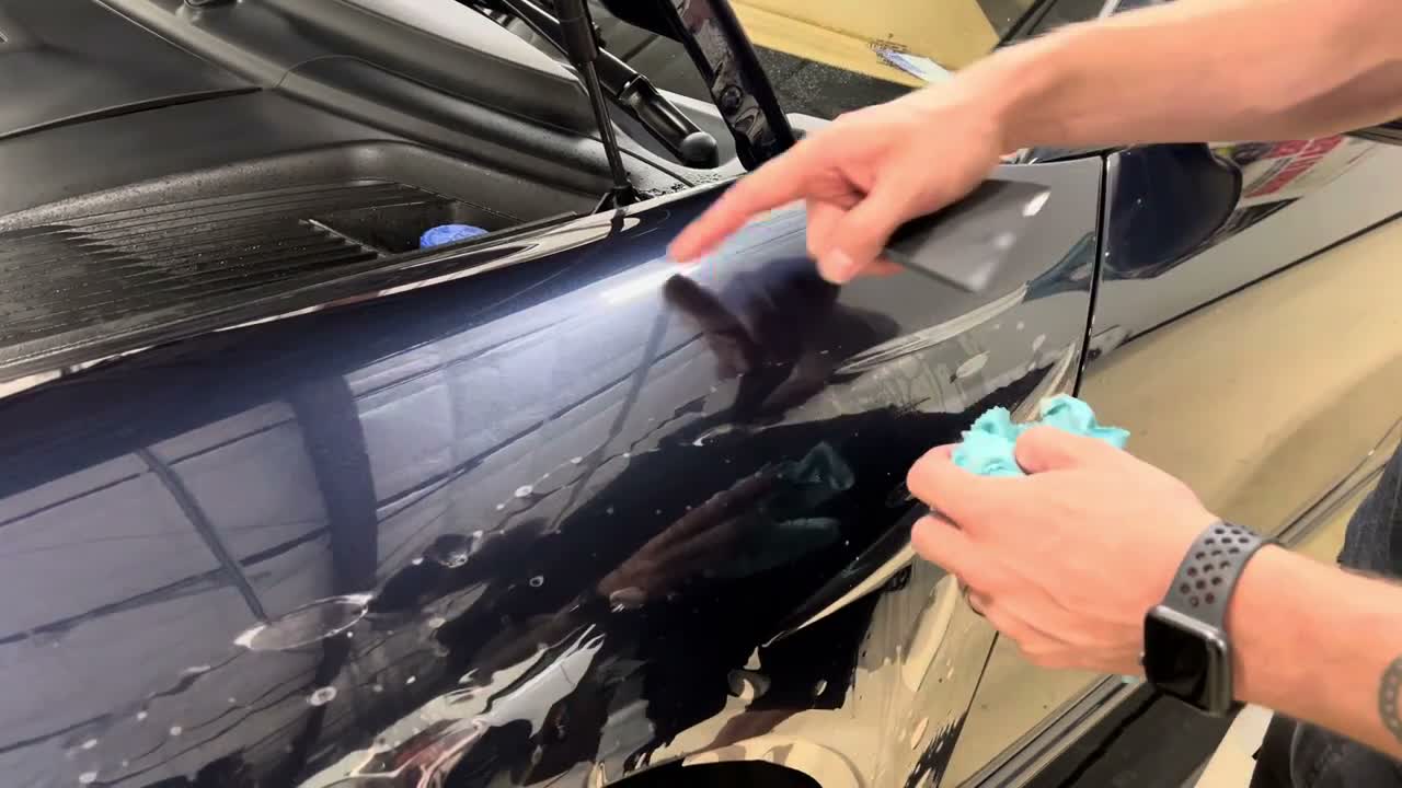 Lift only enough film to remove contamination Lifting a section of PPF to clean beneath the Porsche fender film