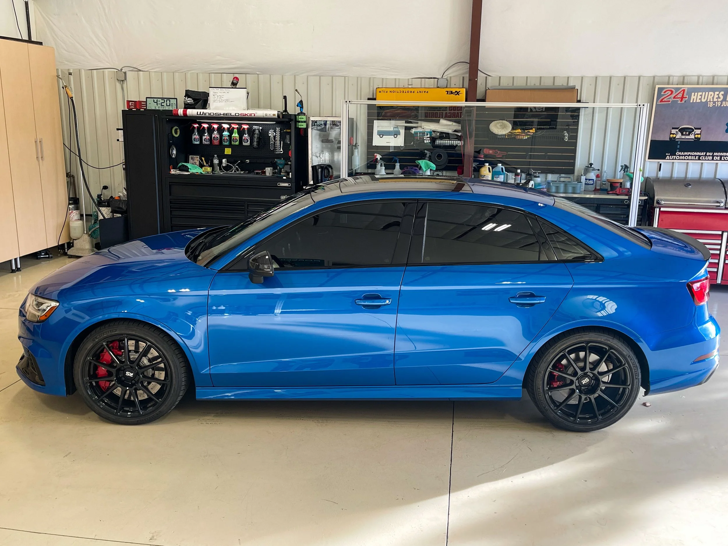 Blue BMW in side profile, showing its tinted front and rear windows