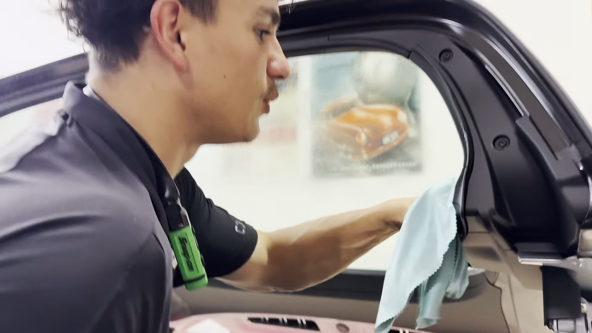 Protect the interior and clean the surrounding trim Installer wiping the plastic trim beneath the Porsche Targa rear window