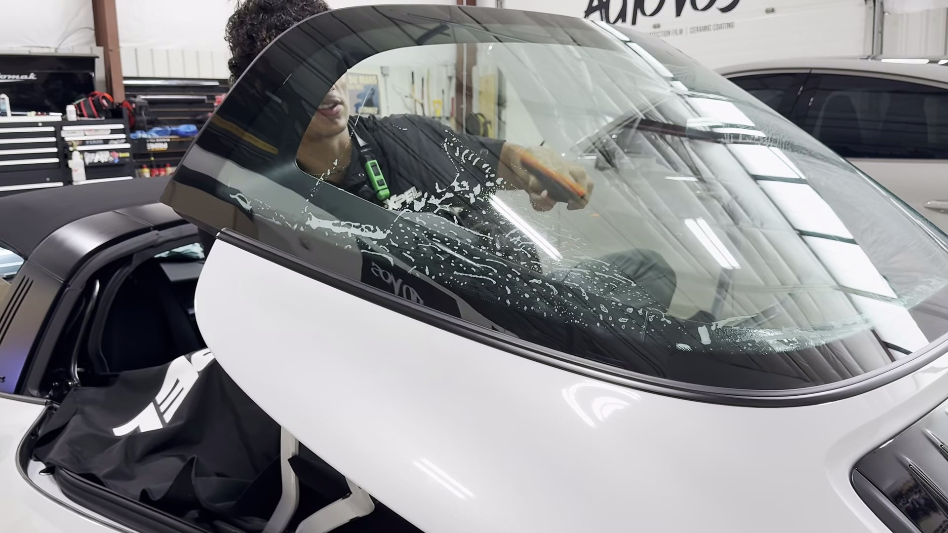 Auto Vos cleaning the inside of a Porsche 911 Targa rear window before fitting tint