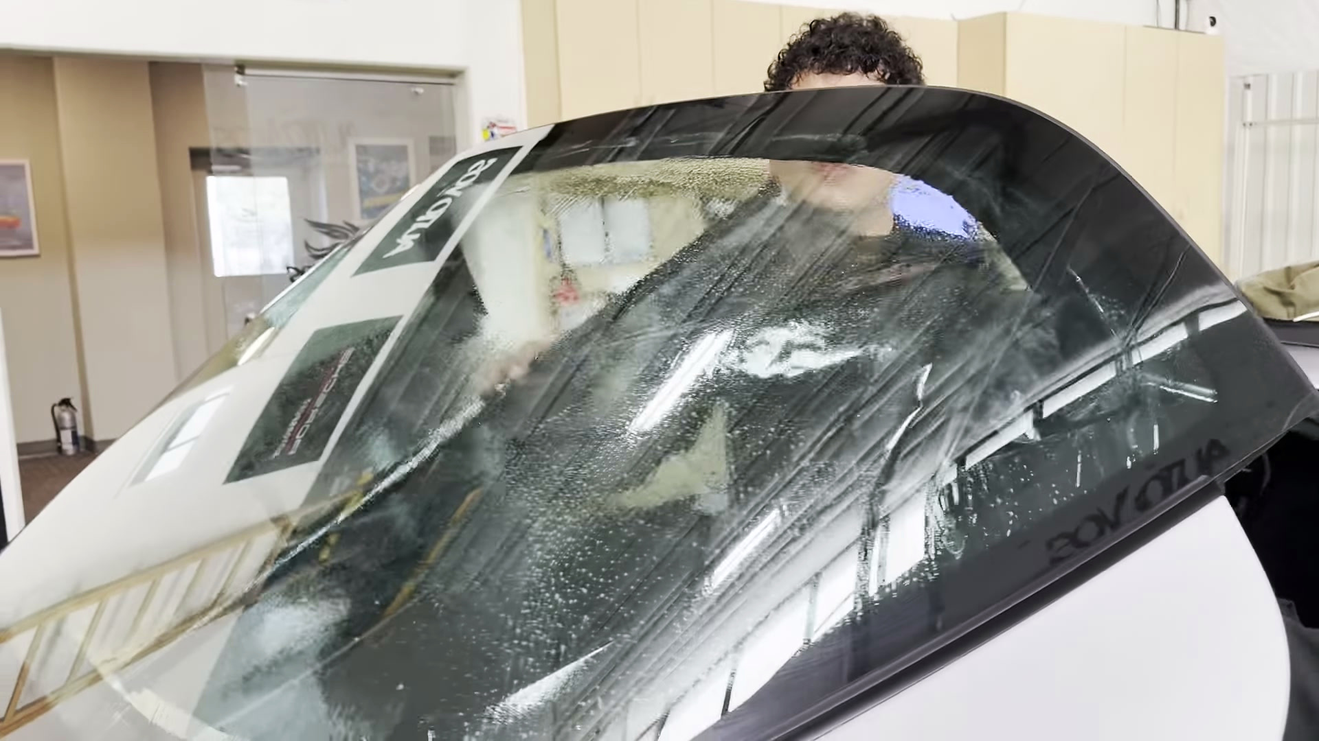 Unroll inside without letting the film catch Tint film being unrolled and supported inside the Targa rear window