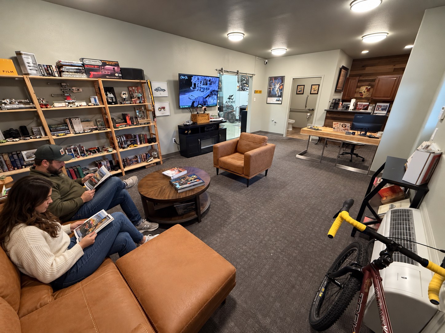 Auto Vos waiting-room visualization with people seated on the left, chairs and display shelves Auto Vos waiting-room visualization with people seated on the left, chairs and display shelves
