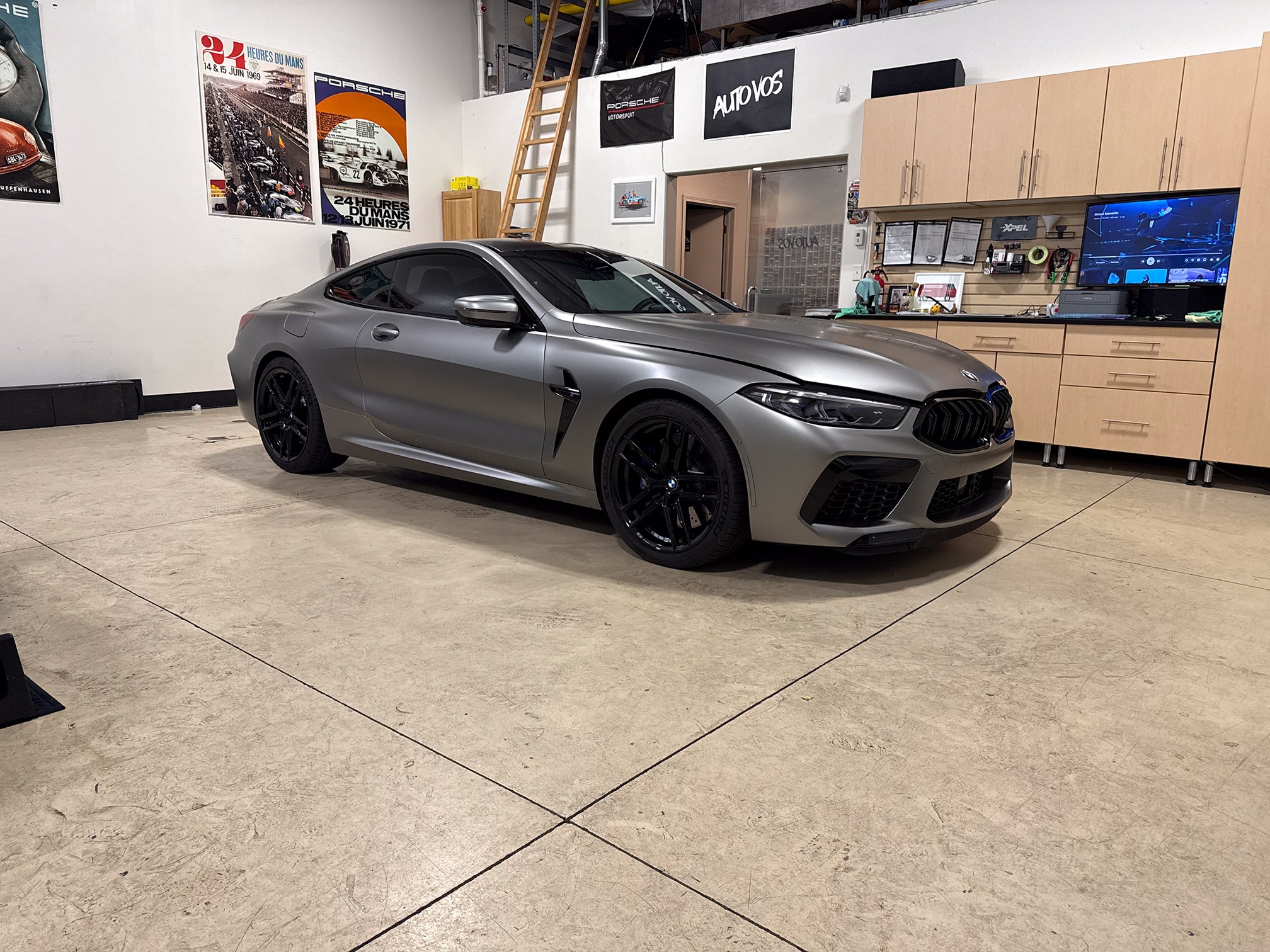 Satin gray BMW coupe with black wheels inside the workshop Satin gray BMW coupe with black wheels inside the workshop