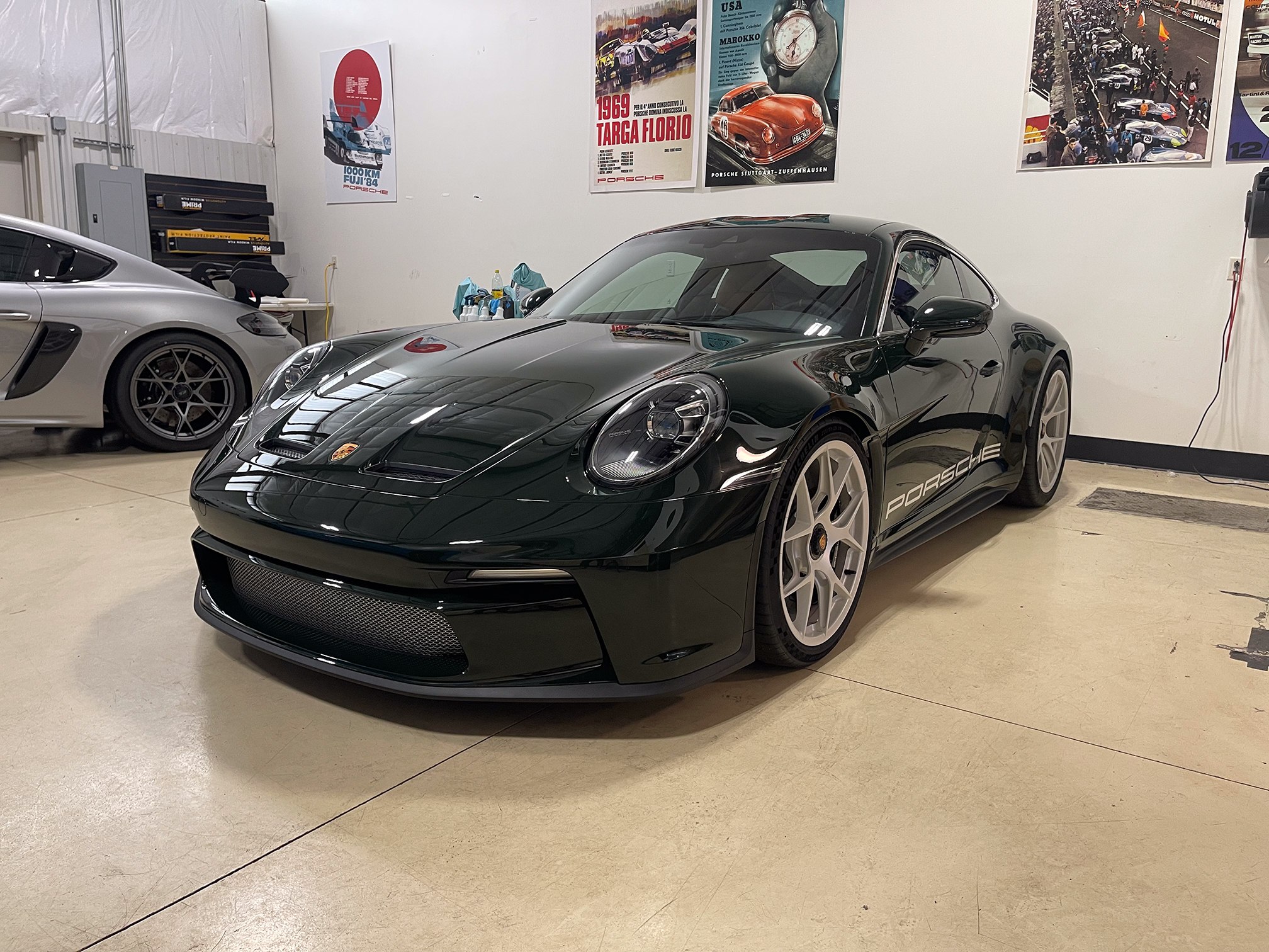 Dark green Porsche 911 with silver wheels in the workshop Dark green Porsche 911 with silver wheels in the workshop