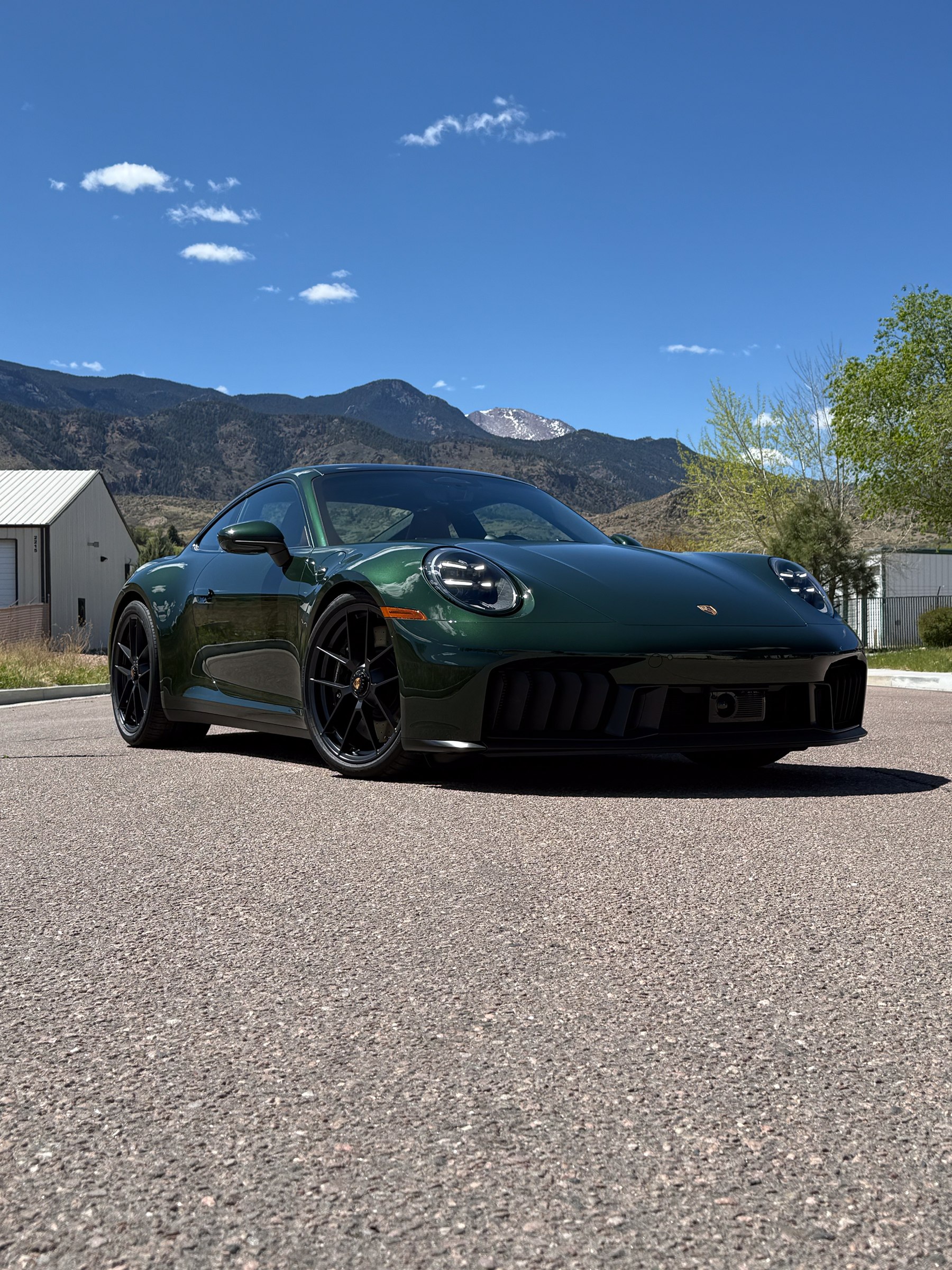 A low green coupe photographed outside the studio, showing its side glass and clean profile A low green coupe photographed outside the studio, showing its side glass and clean profile.
