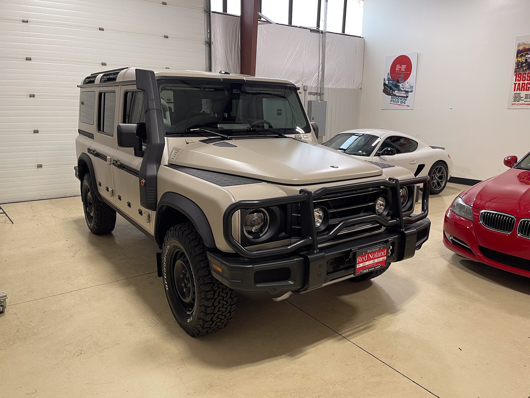 Beige INEOS Grenadier with a satin finish inside the Auto Vos workshop