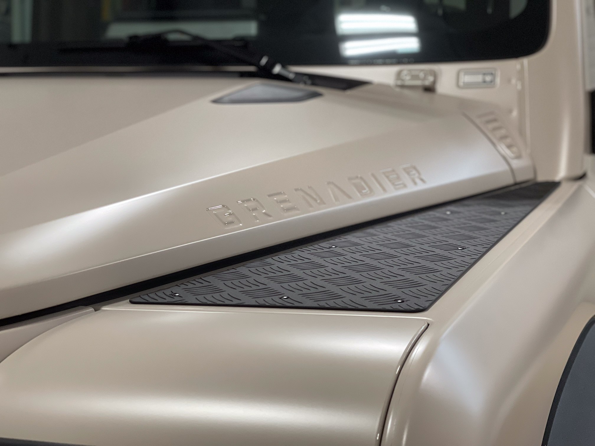 Close-up of the Grenadier name embossed on a beige satin hood Close-up of the Grenadier name embossed on a beige satin hood