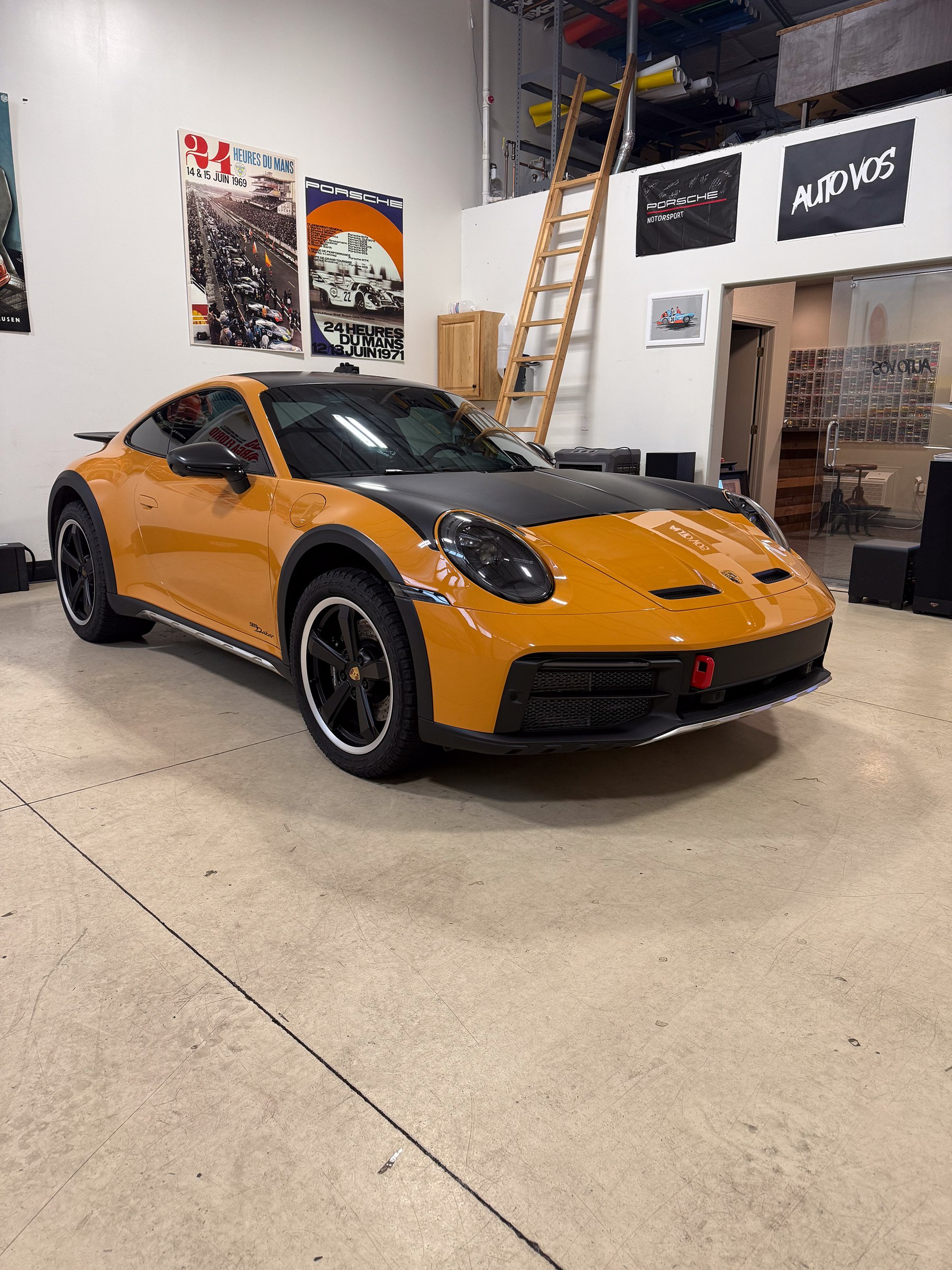 Orange Porsche 911 with a dark hood and roof inside the workshop Orange Porsche 911 with a dark hood and roof inside the workshop