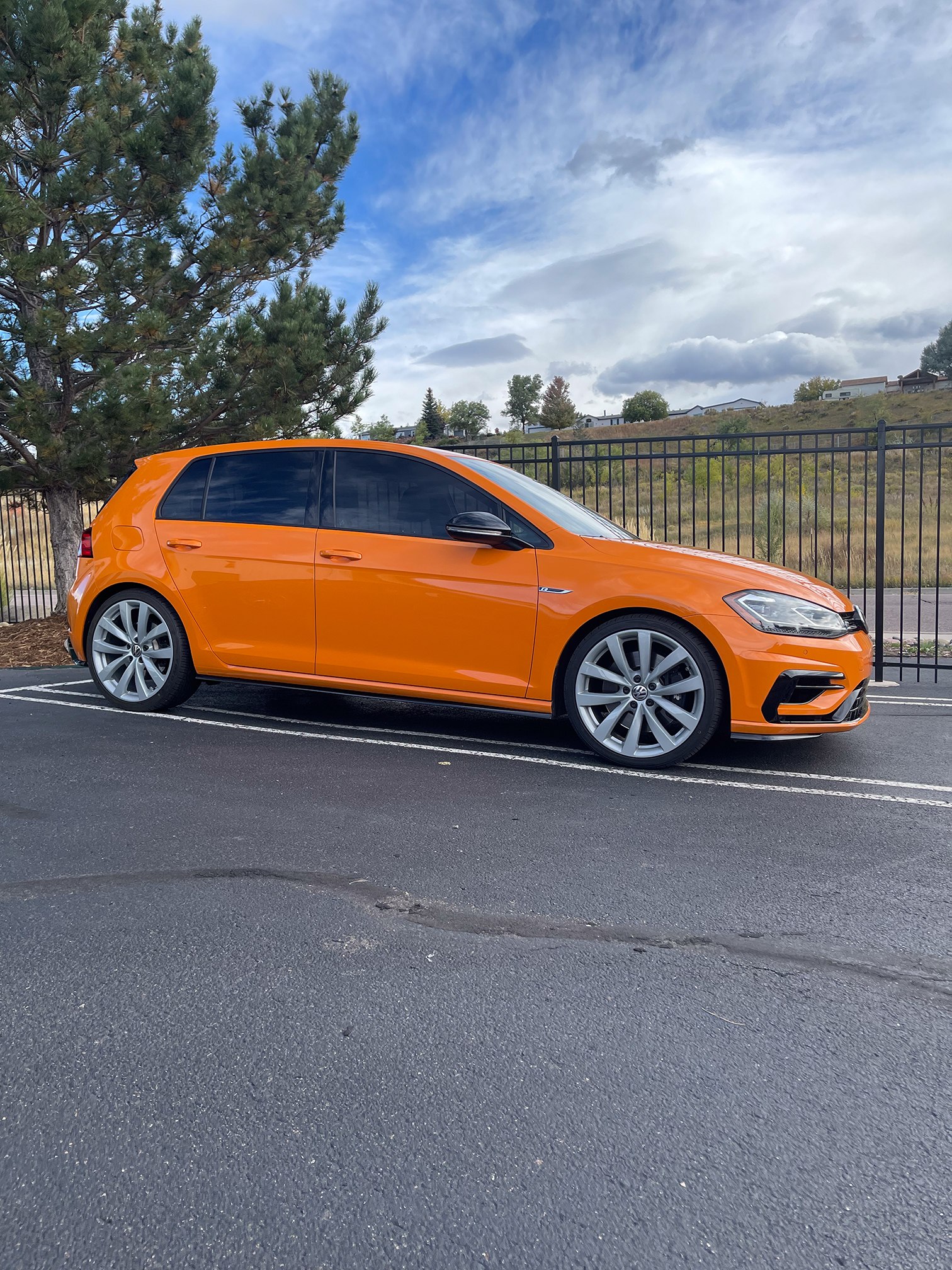 Orange Volkswagen Golf in side profile outside the workshop Orange Volkswagen Golf in side profile outside the workshop