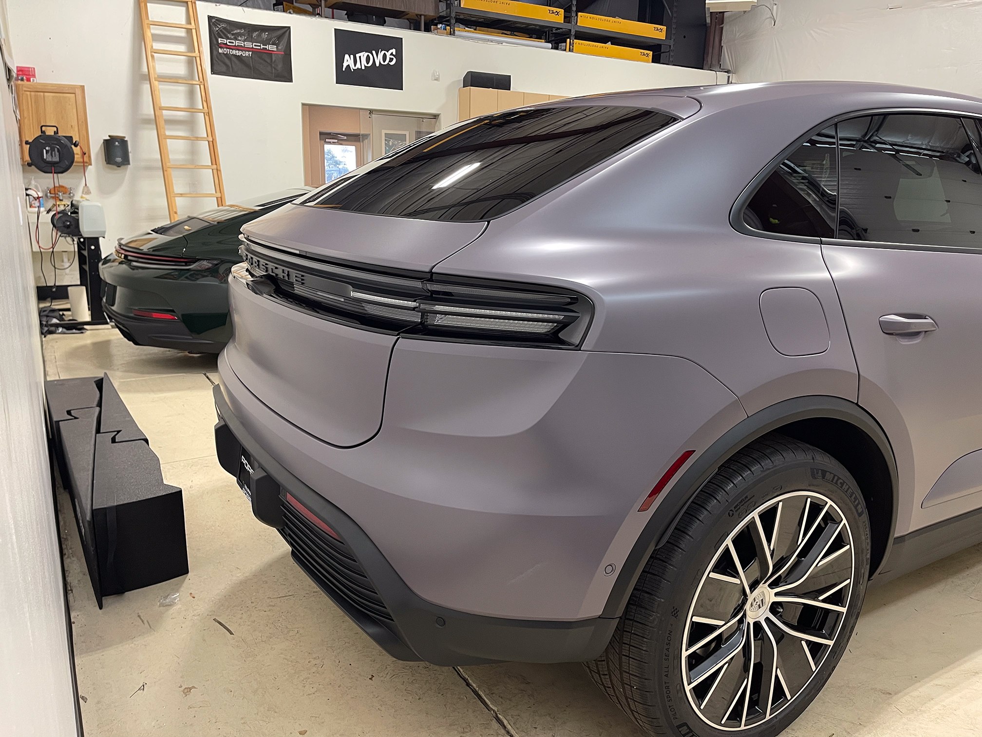 Rear three-quarter view of a satin lavender-gray Porsche Macan Rear three-quarter view of a satin lavender-gray Porsche Macan