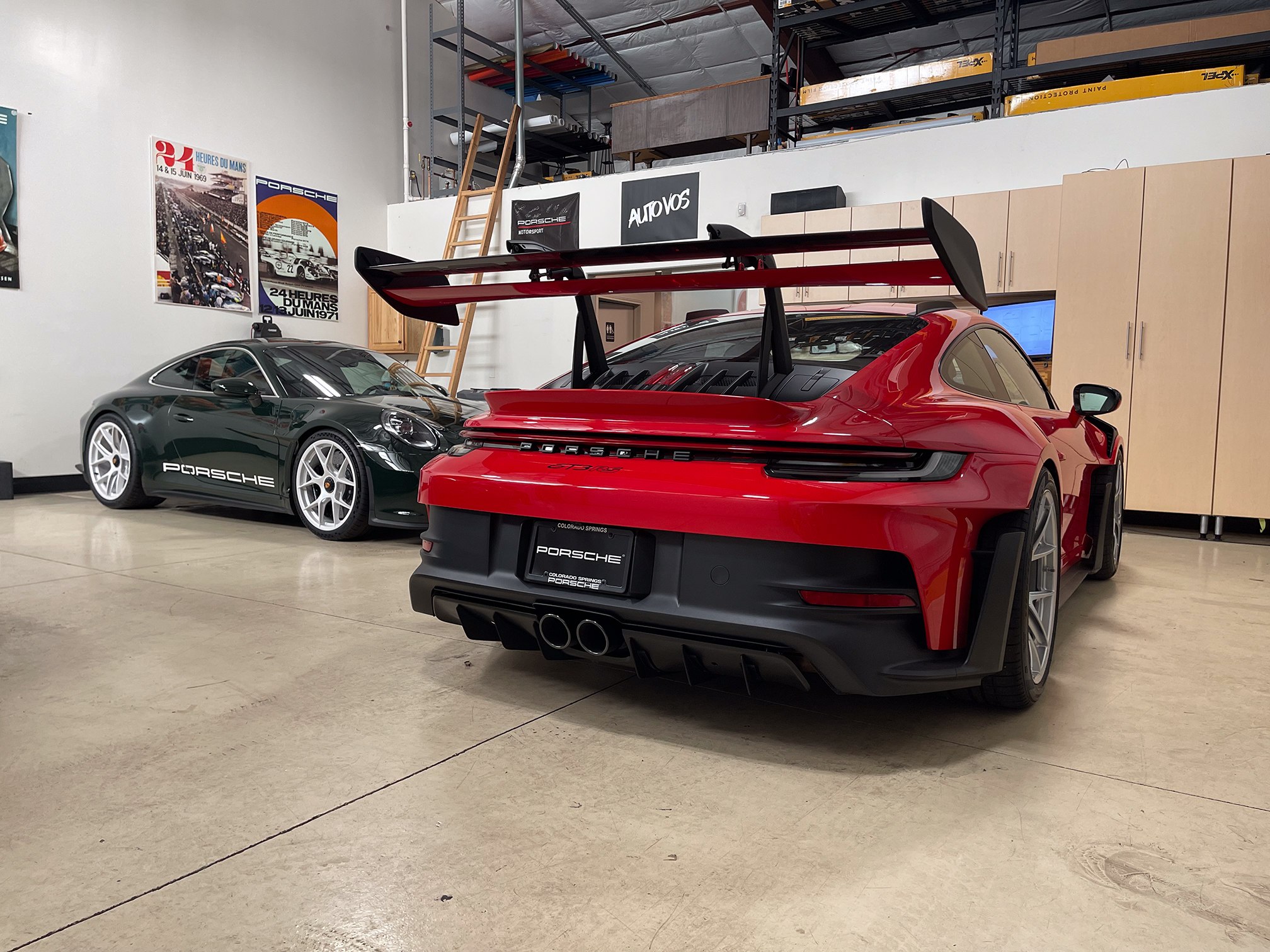 Rear view of a red Porsche 911 with a large wing and dark rear bumper Rear view of a red Porsche 911 with a large wing and dark rear bumper