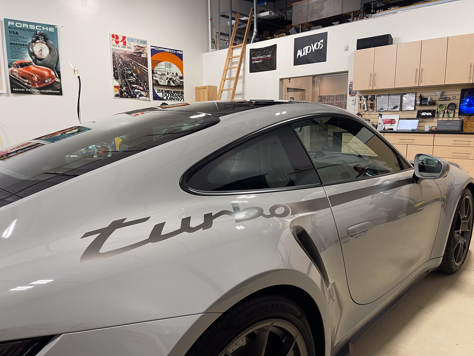 A close side view highlights the door glass and sculpted bodywork of a silver coupe A close side view highlights the door glass and sculpted bodywork of a silver coupe.