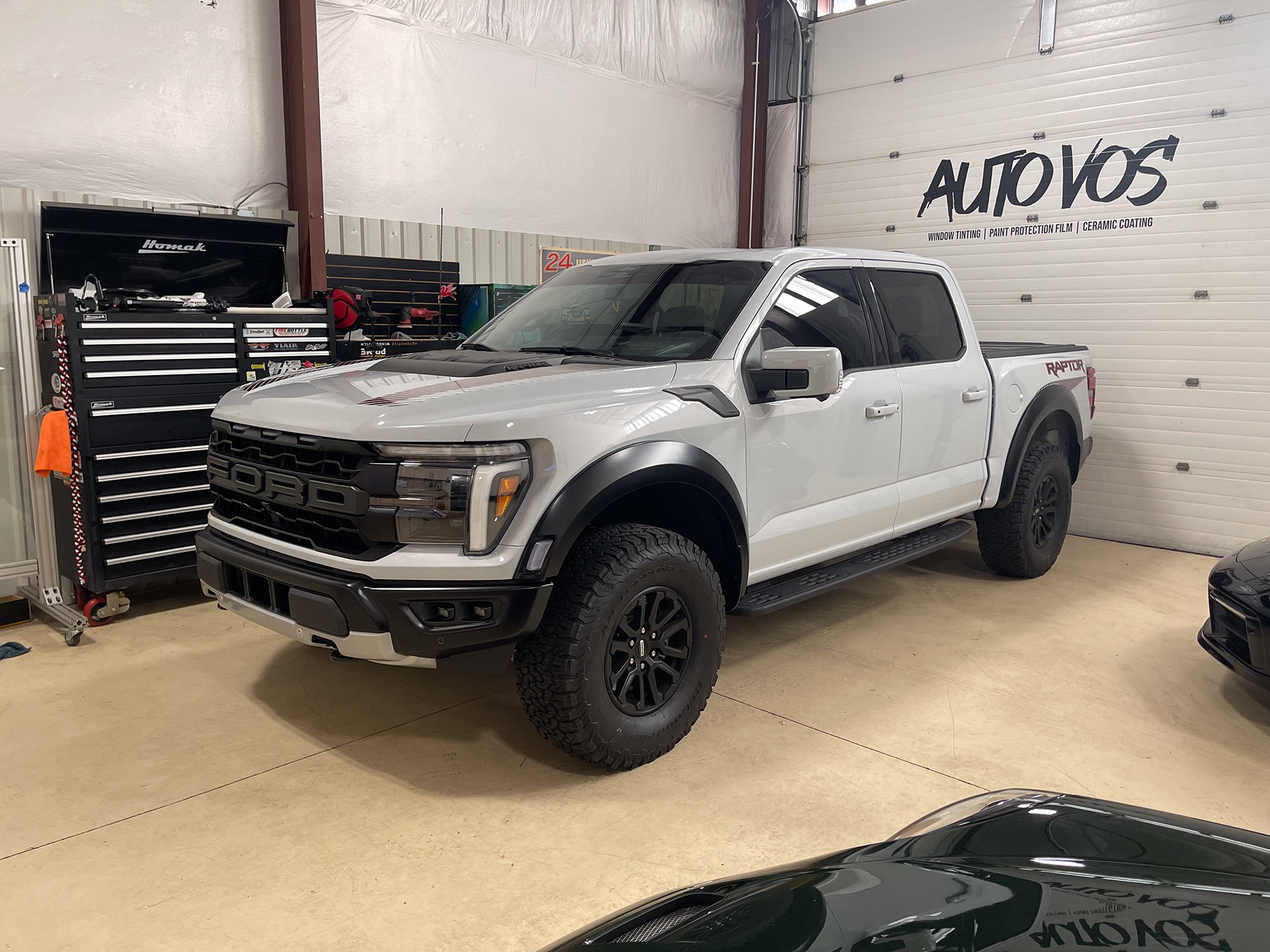 Silver Ford pickup with black wheels inside the Auto Vos workshop Silver Ford pickup with black wheels inside the Auto Vos workshop