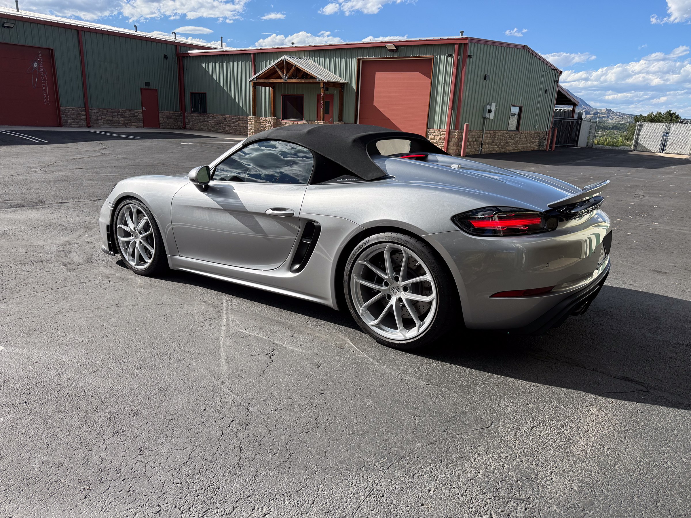 Silver Porsche convertible with a black roof outside Auto Vos Silver Porsche convertible with a black roof outside Auto Vos