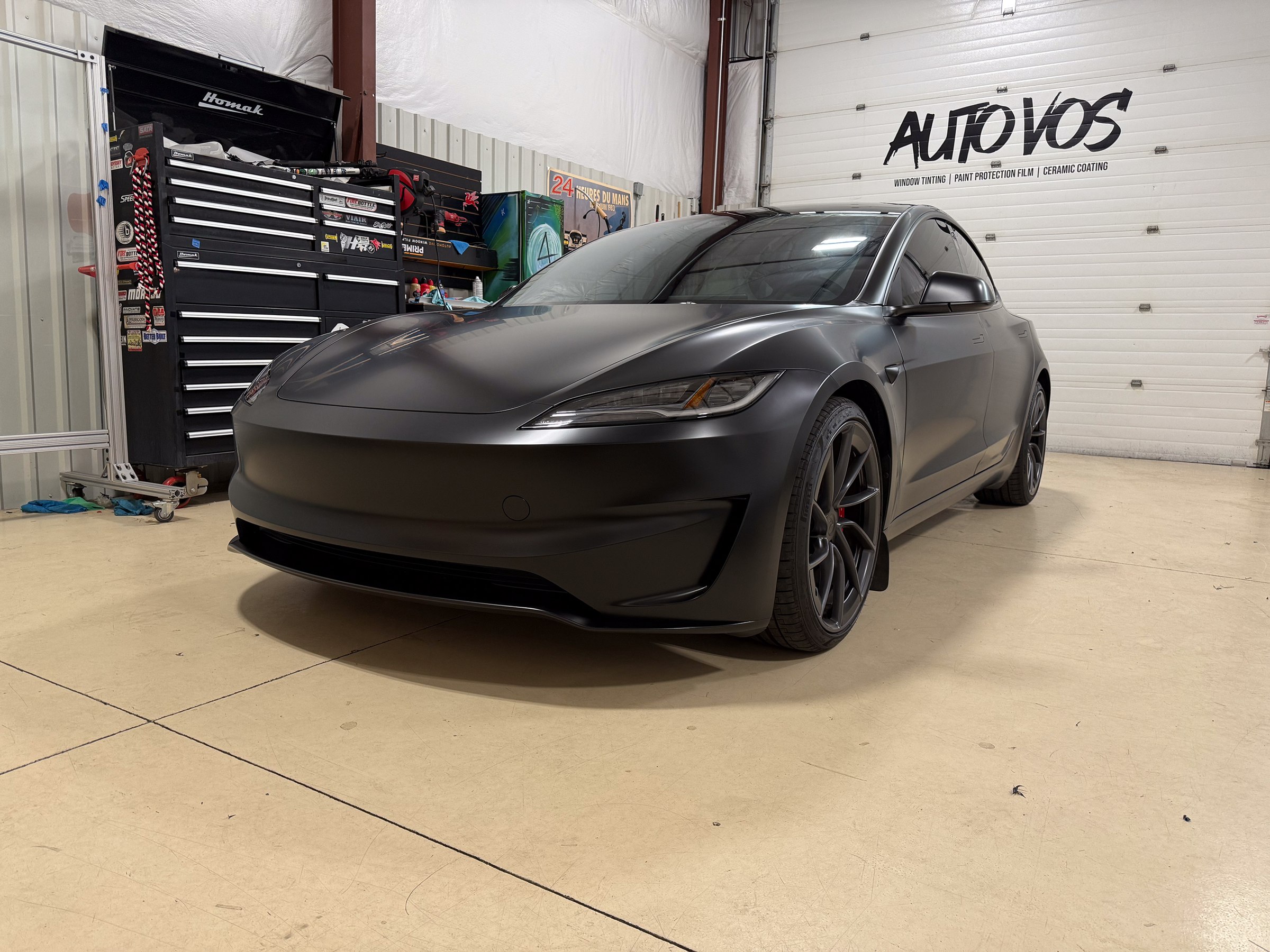 Dark matte Tesla photographed from the front quarter Dark matte Tesla photographed from the front quarter