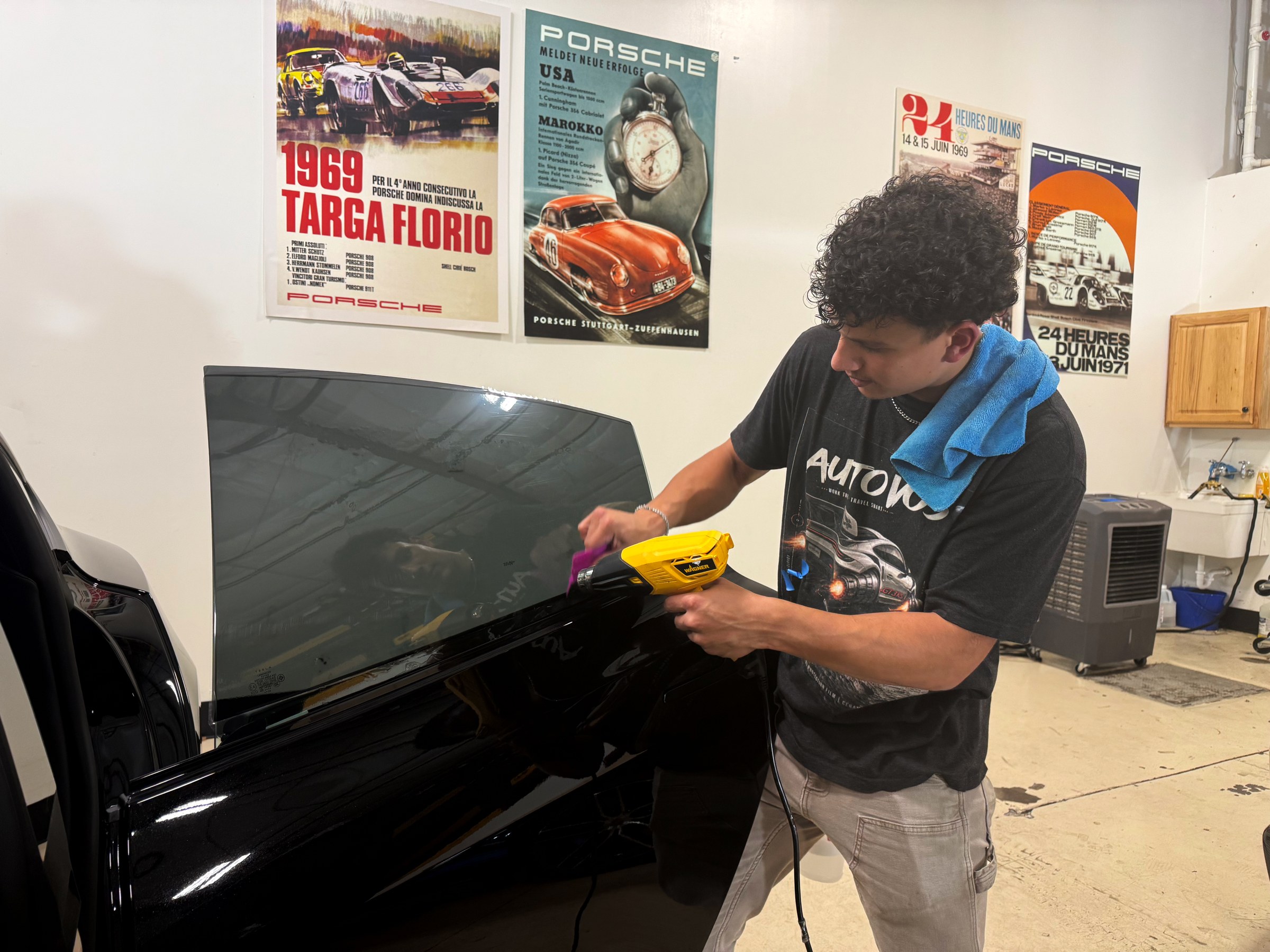 Installer working window tint across a car’s side glass