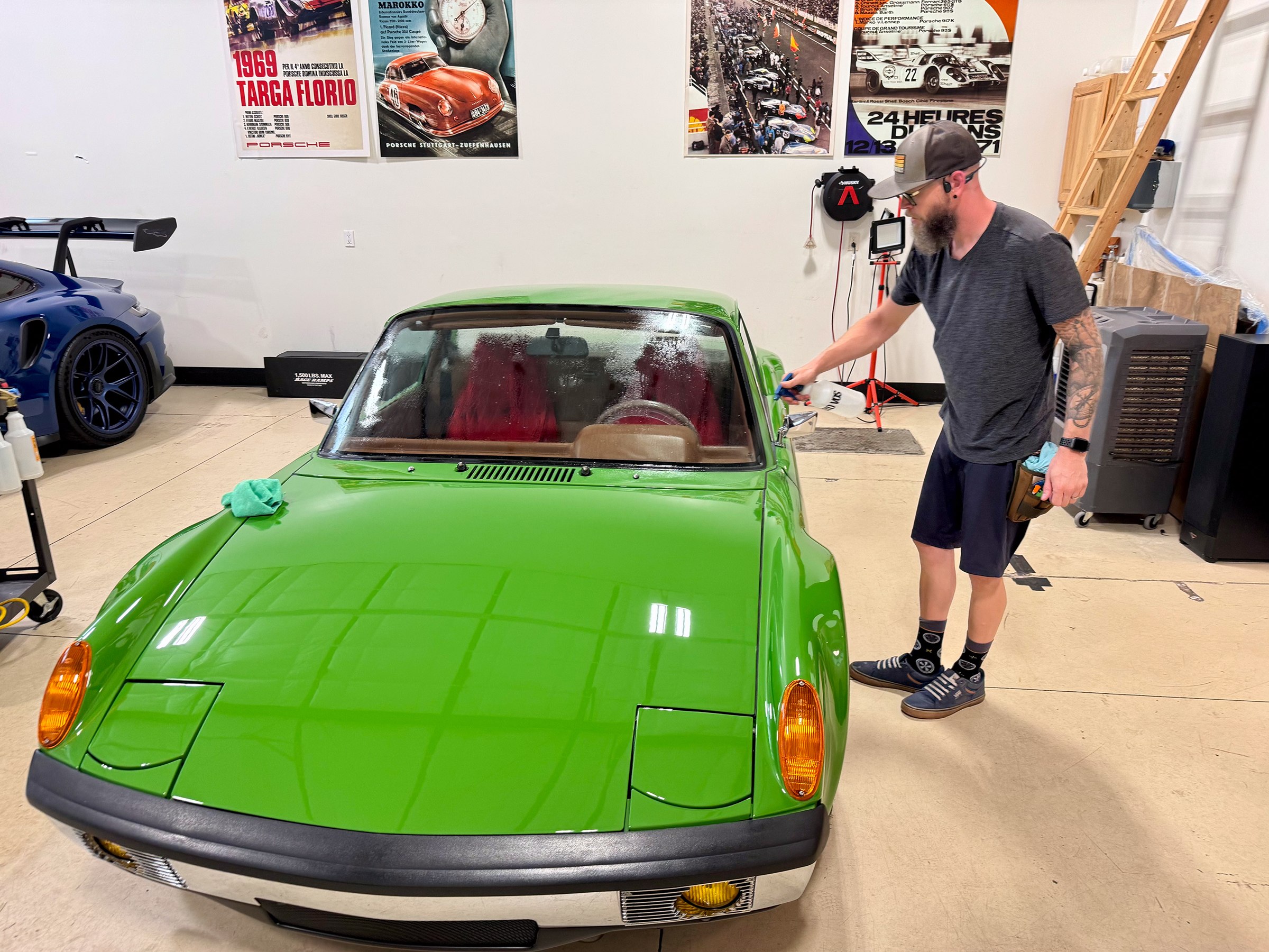 Installer working across the green Porsche 914 windshield Installer working across the green Porsche 914 windshield