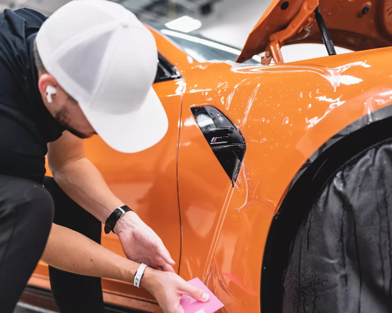 XPEL paint protection film being fitted to a painted panel